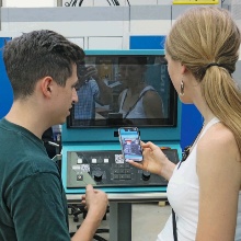 Eine junge Frau und ein junger Mann testen die Augmented Reality App am Bildschirm