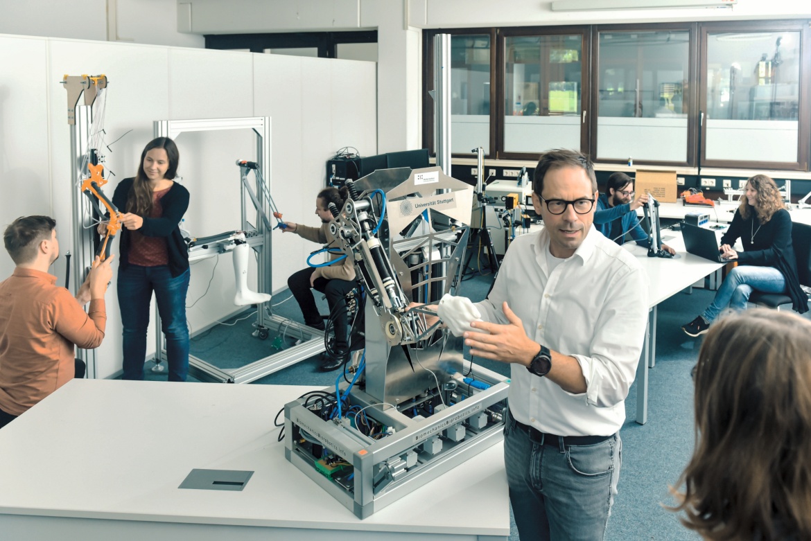 Photograph of Prof. Syn Schmitt and a robot arm