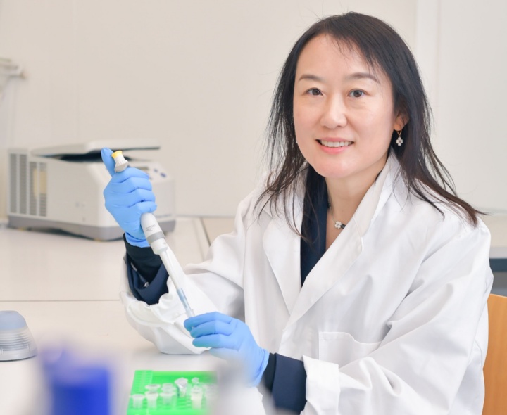 Prof. Laura Na Liu in the laboratory. She wears a white lab coat.