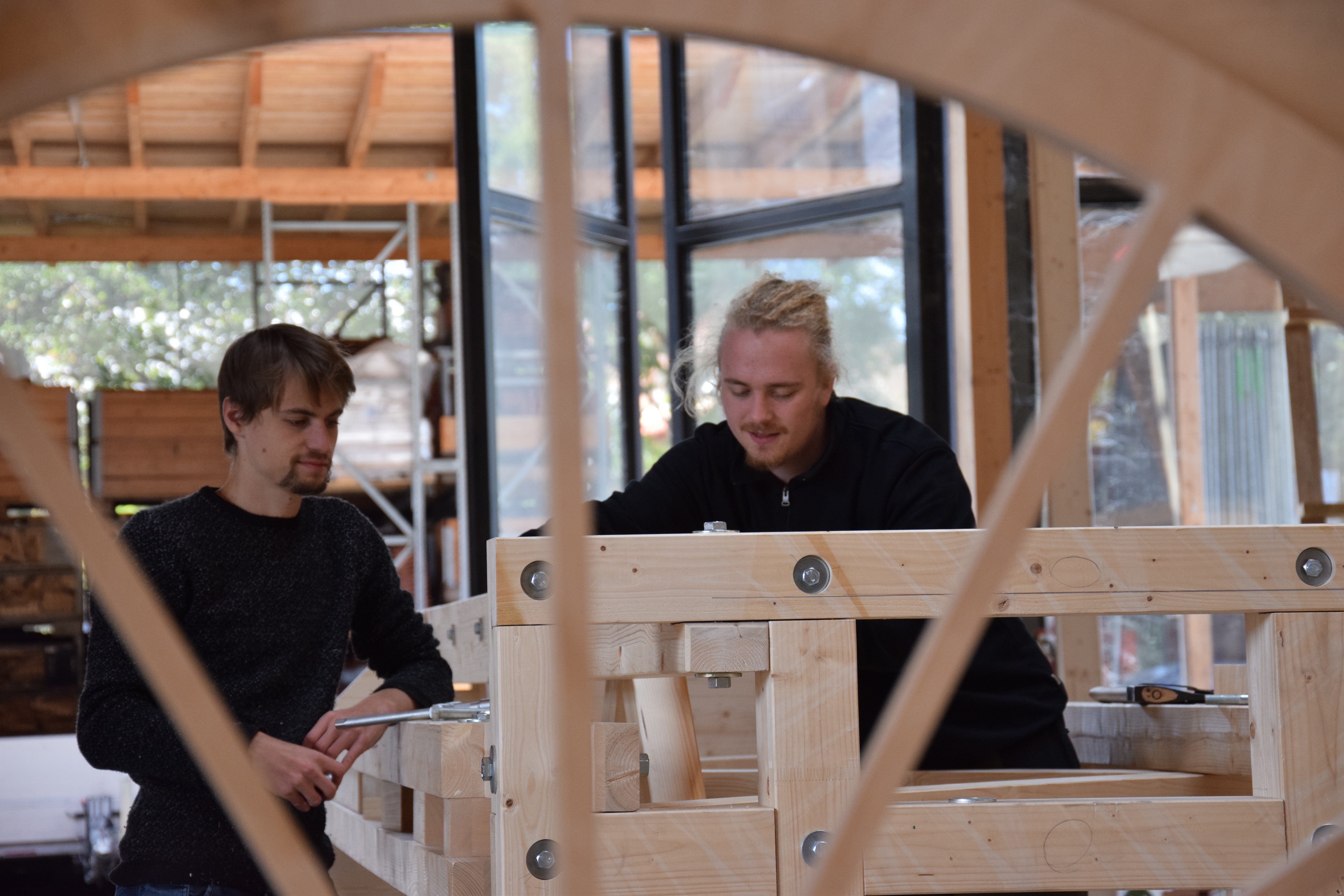 Zwei Studenten bauen am Holzkorpus der Luftbahn
