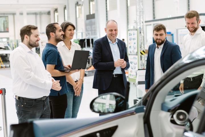 A team of researchers inspects a car.