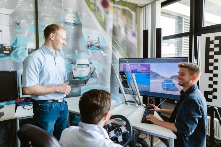 Three researchers perform a simulated car ride on a computer.