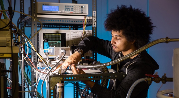 An international young person works intently in a laboratory.