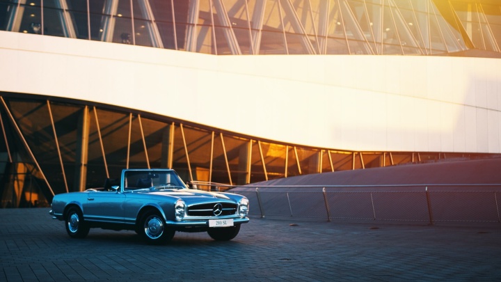 A Mercedes stands in front of a modern building