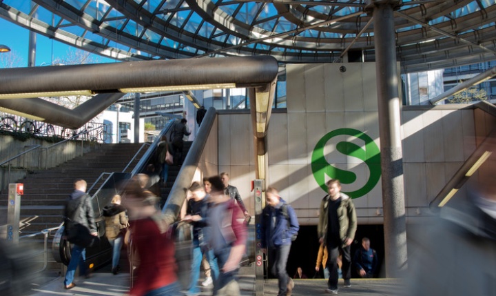 Many students walk by in front of the tram station