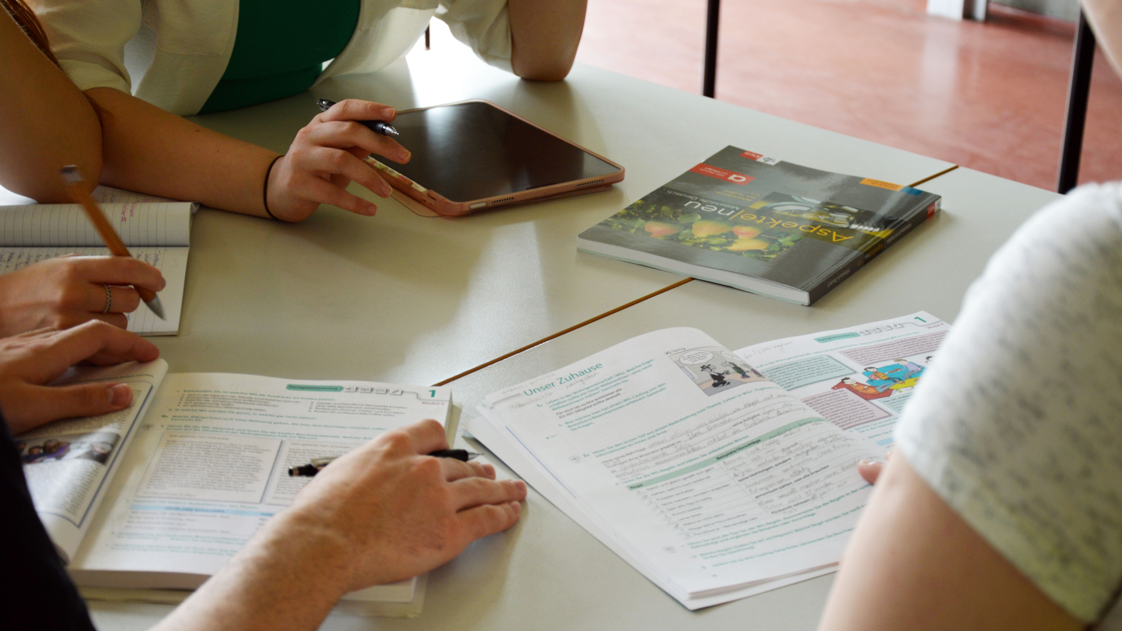 A table with learning materials and a tablet.