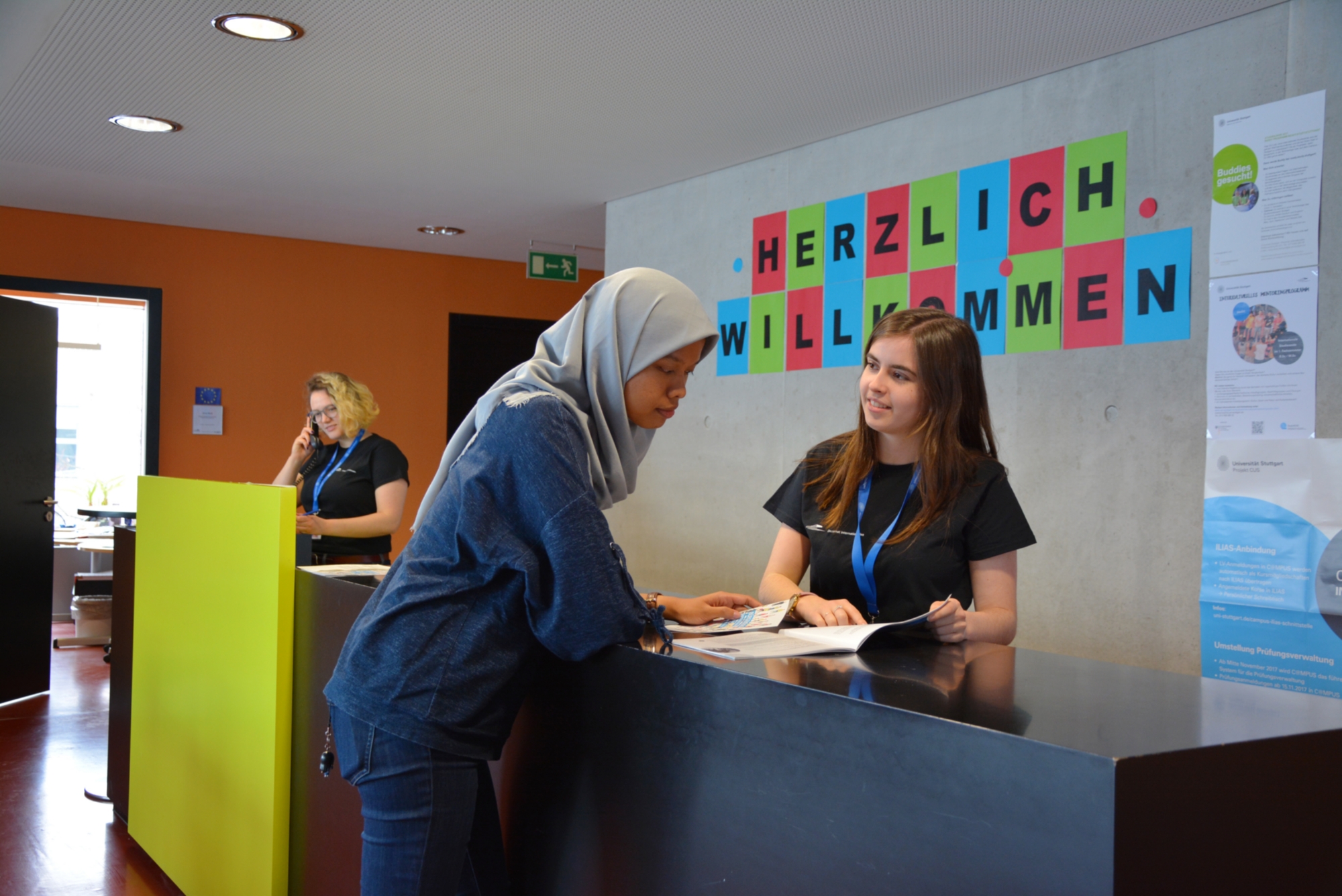 A foreign student is adviced by another student in the International Office of the University of Stuttgart.