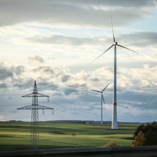 Windräder und Stromtrassen in einer ländlichen Landschaft