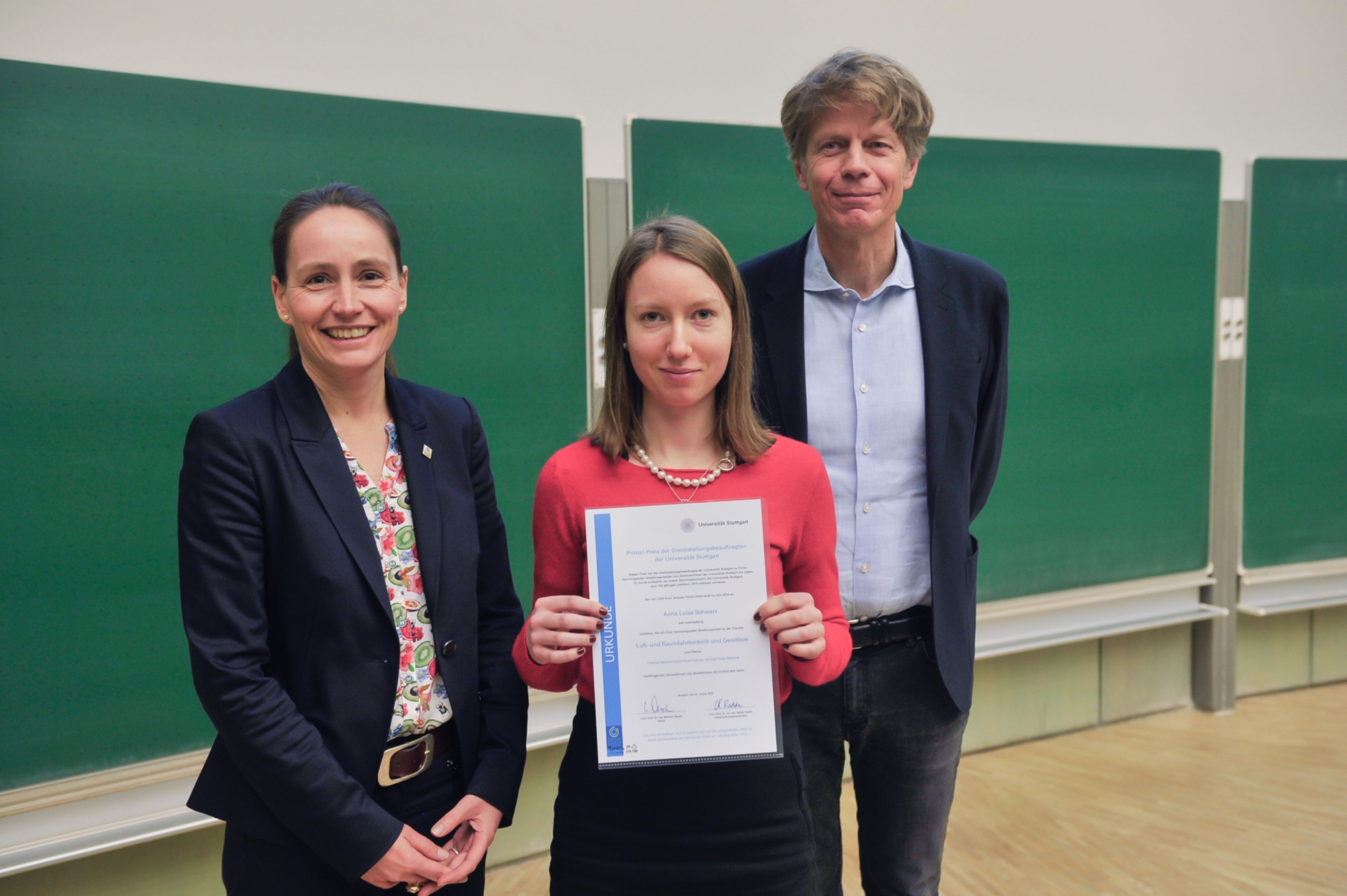 Die Gleichstellungsbeauftragte Prof. Nicole Radde (li.) und Prof. Jan Knippers übergeben Anna Schwarz eine Urkunde.