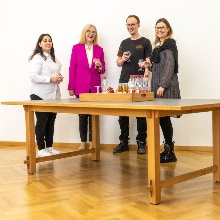 Von links nach rechts: Auszubildende Irem Bakan, Kanzlerin Anna Steiger, Auszubildender Daniel Schwarz und Personalentwicklerin Katrin Böhm, stehend am Schreibtisch der Kanzlerin.