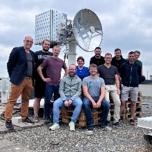 Das Forscherteam vom ILH posiert für ein Gruppenfoto vor der Bodenstation auf dem Dach des Pfaffenwalrings 31 auf dem Campus Vaihingen.