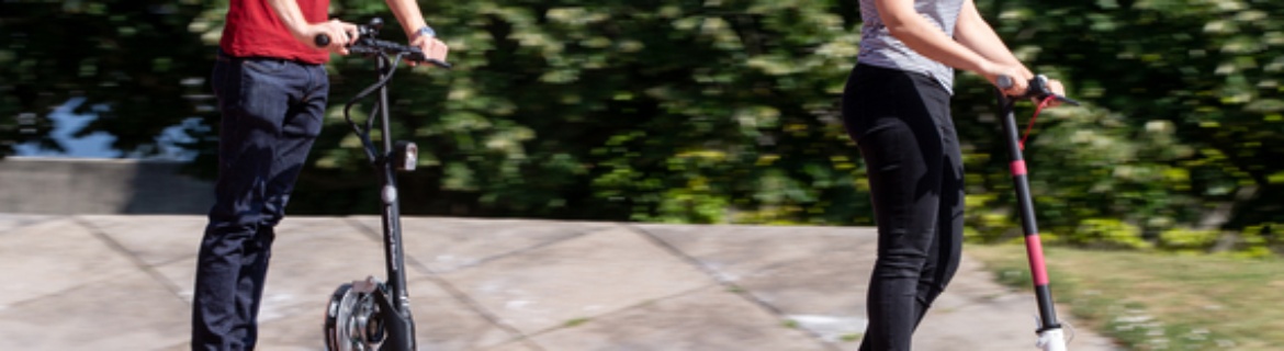 A man and a woman are driving on E-scooters on the Campus Vaihingen.