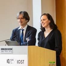 Professorin Stefanie Barz (rechts im Bild) und Professor Fedor Jelezko (links im Bild) von IQST gemeinsam am Rednerpult auf der Bühne. 