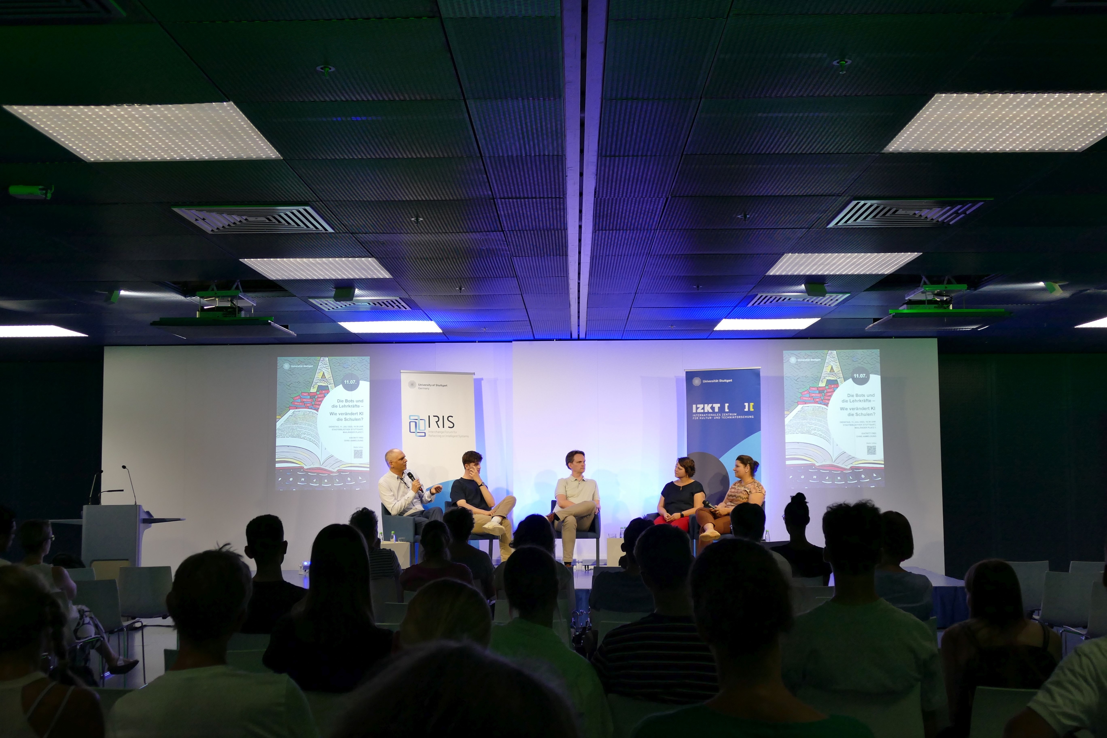 Students discuss on stage with teachers and experts in front of an audience