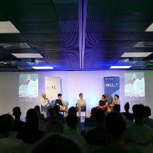 Students discuss on stage with teachers and experts in front of an audience