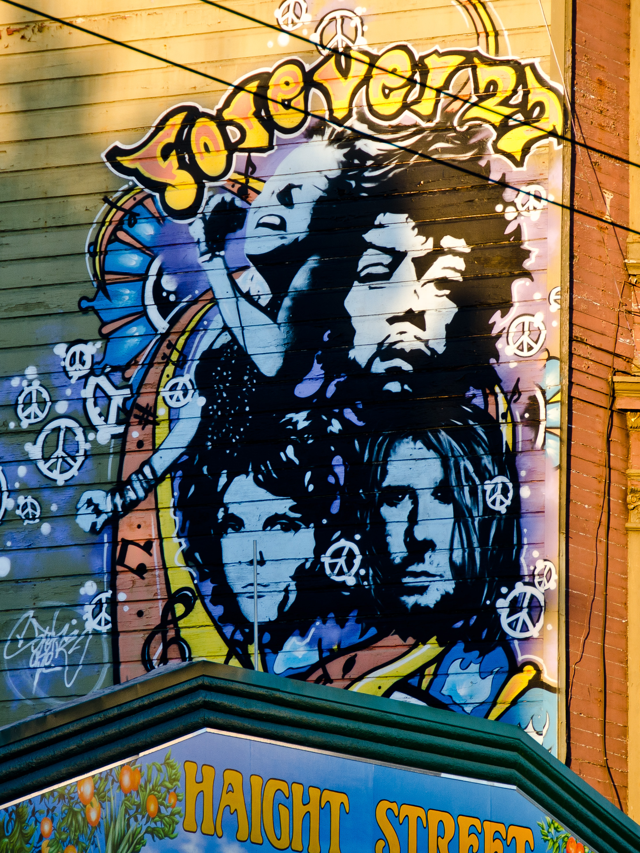 Graffiti showing Jimi Hendrix, Brian Jones, Janis Joplin and Jim Morrison on a house wall.