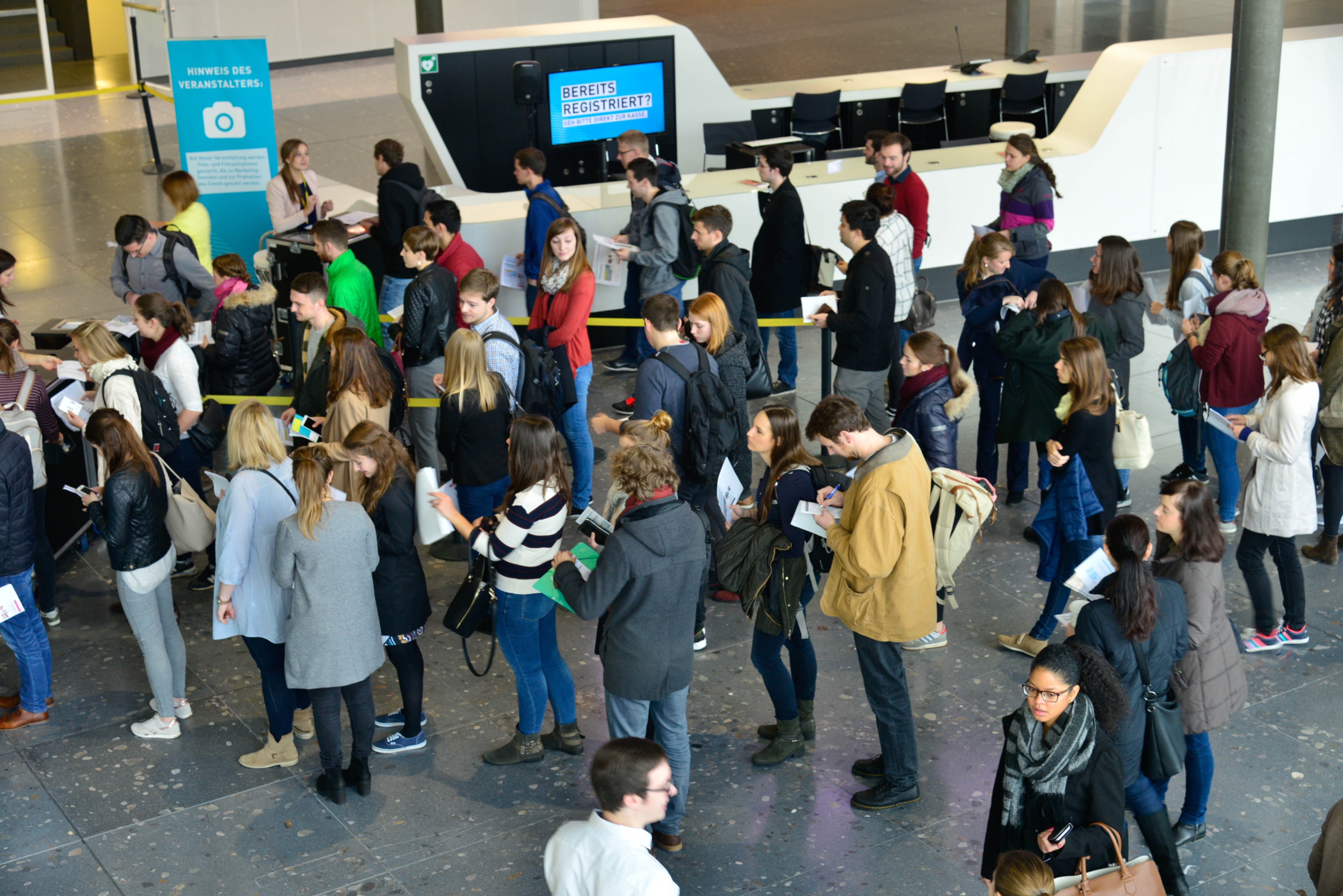 Leute stehen in einer Schlange in der Messehalle