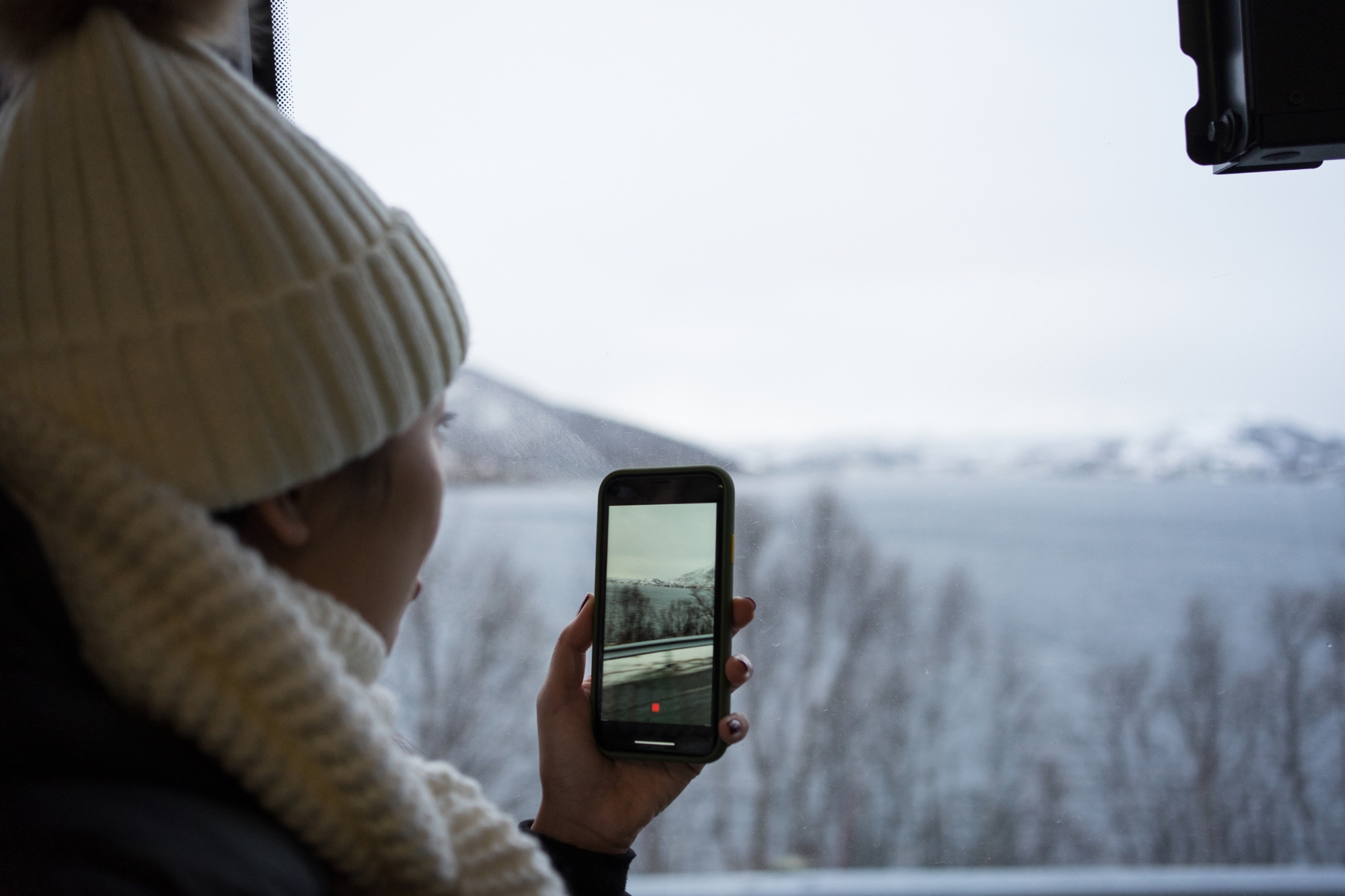 Person takes a picture of a sunset with his smartphone.