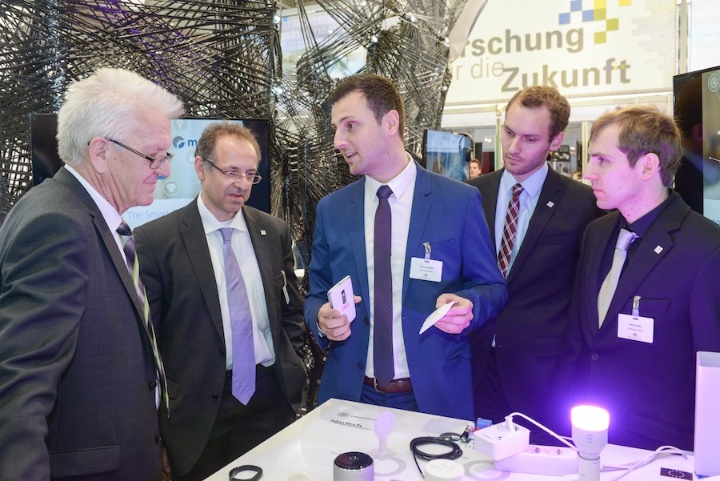 Ministerpräsident Winfried Kretschmann lässt sich von Prof. Albrecht Schmidt, Thomas Kubitza, Matthias Mögerle und Patrick Bader das Konzept ihres Startups meSchup zeigen.