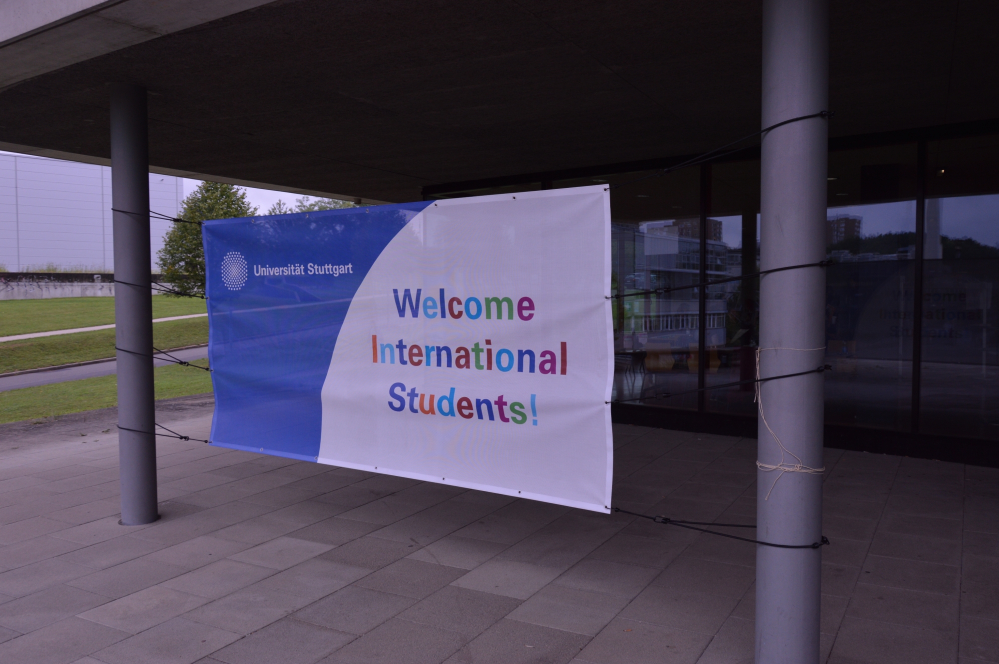 Ein Banner ist vor einem Gebäude befestigt mit der Aufschrift "Welcome International Students"