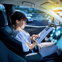 Lesende junge Frau in einem autonomen Fahrzeug