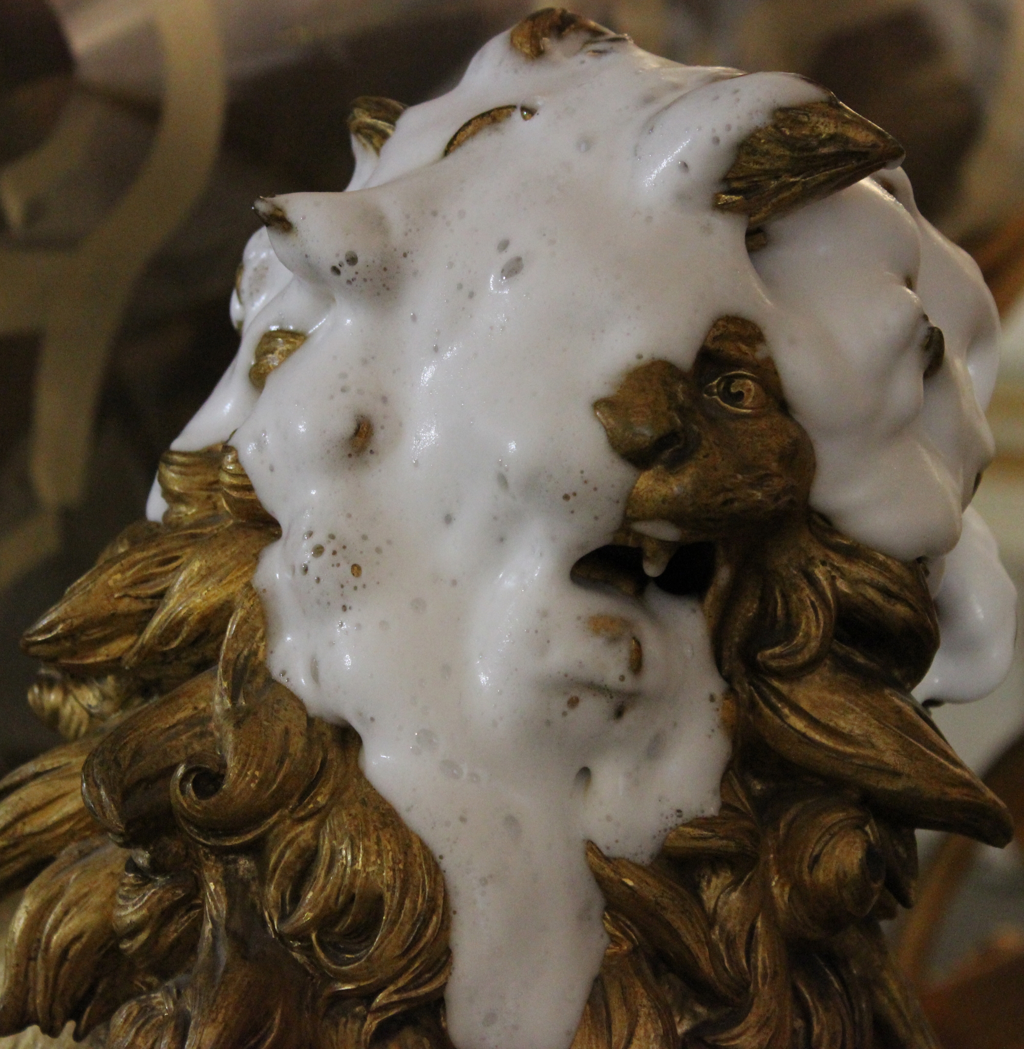 Kopf einer Löwenskulptur während der Reinigung mit Schaum