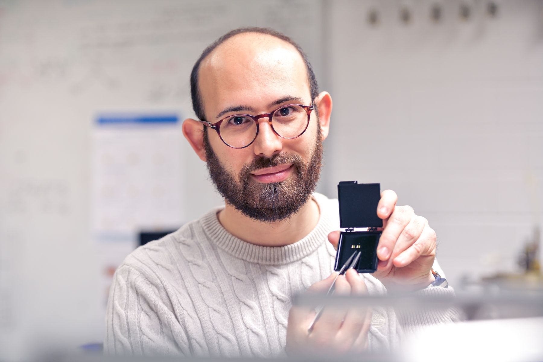 Portraitbild von Lorenzo Tesi welcher einen Prototypen in der Hand hält.