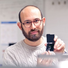Portraitbild von Lorenzo Tesi welcher einen Prototypen in der Hand hält.