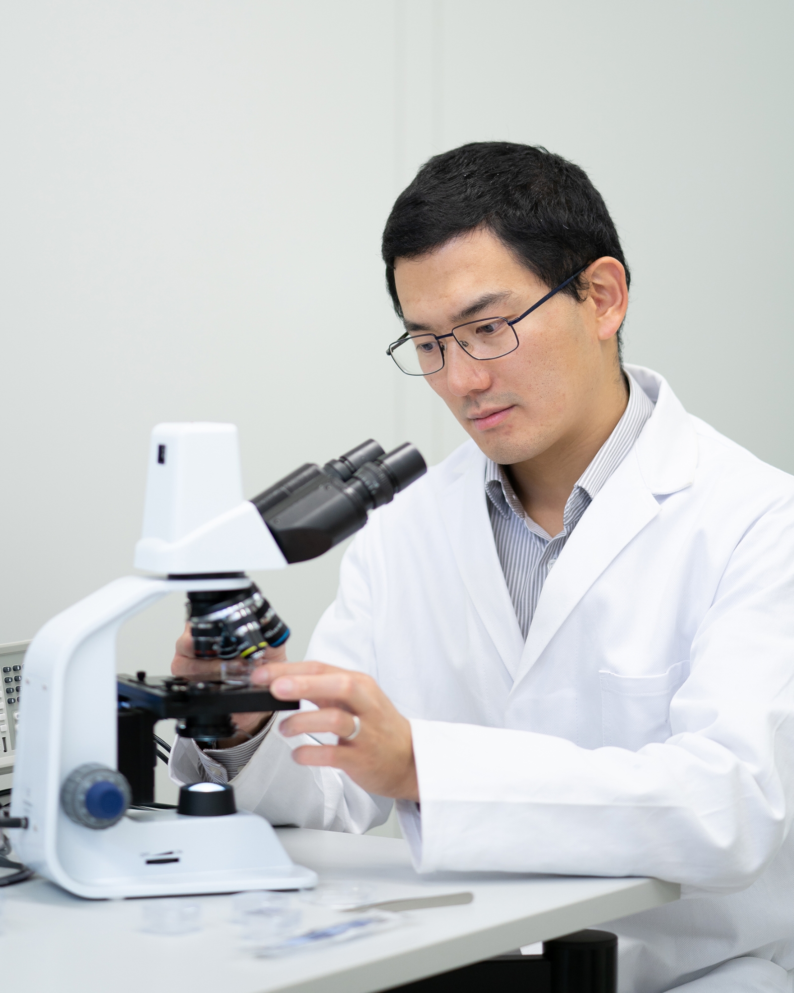 Dr. Tian Qiu an einem Mikroskop