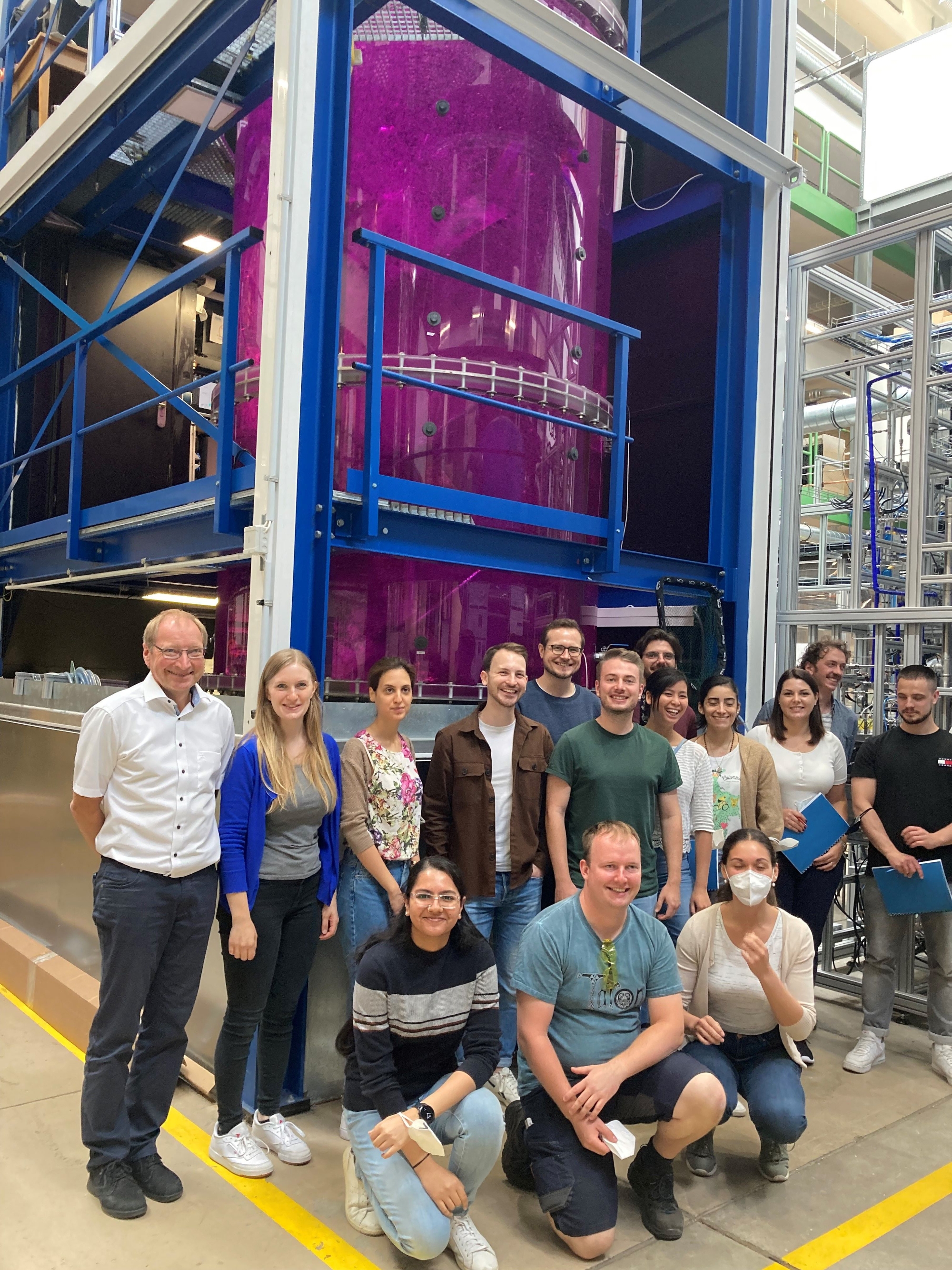 Gruppe Forschende vor dem  „gläsernen“ Bioreaktor am Institut für Multiphasenströmung, TUHH