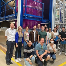 Gruppe Forschende vor dem  „gläsernen“ Bioreaktor am Institut für Multiphasenströmung, TUHH