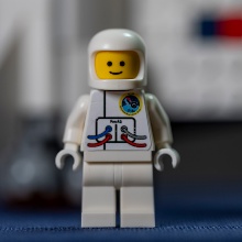 An astronaut lego figure with the FerrAS logo on its chest.