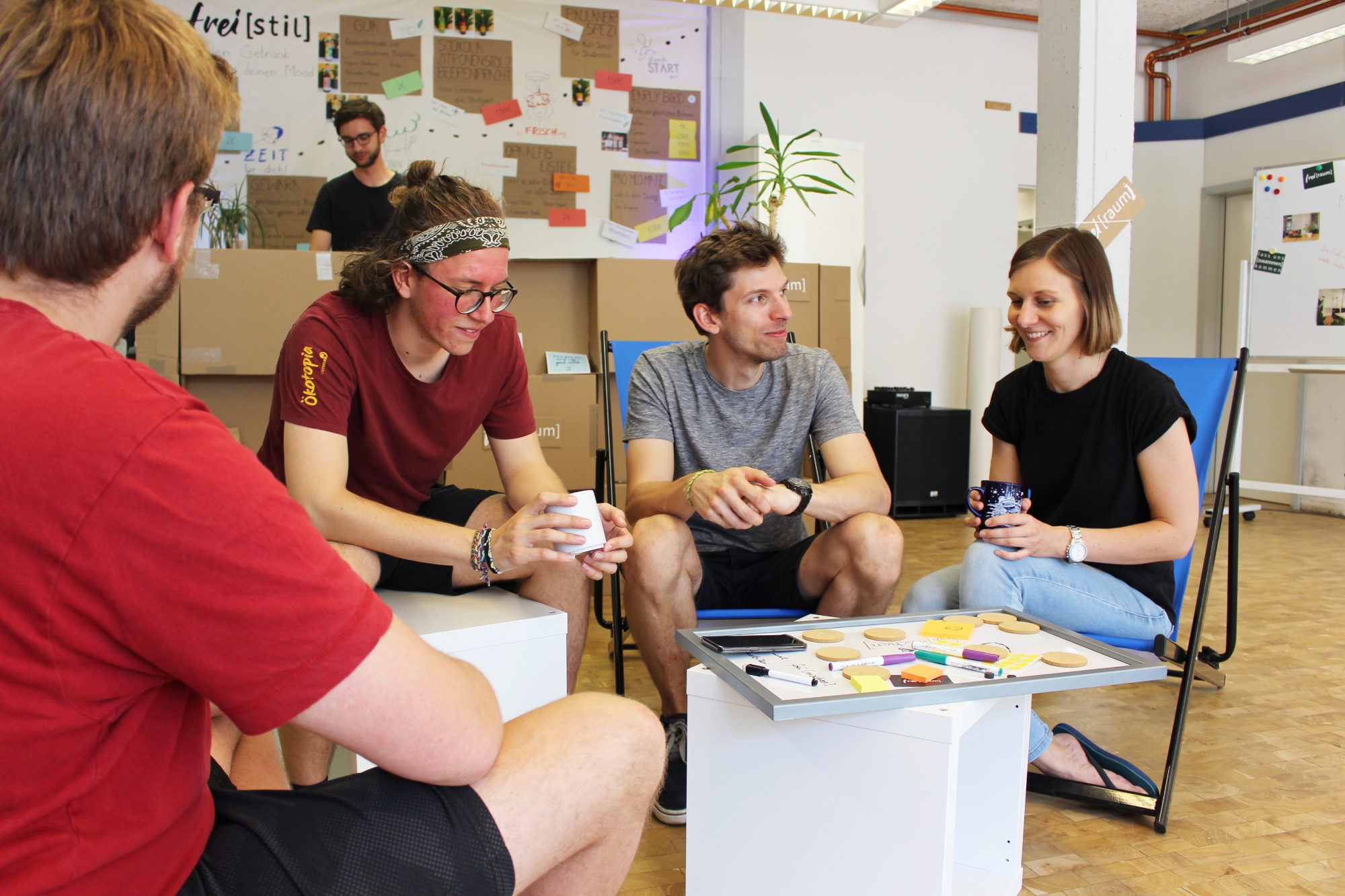 Studierende sitzen gemütlich im Gründercafé auf Liegestühlen.