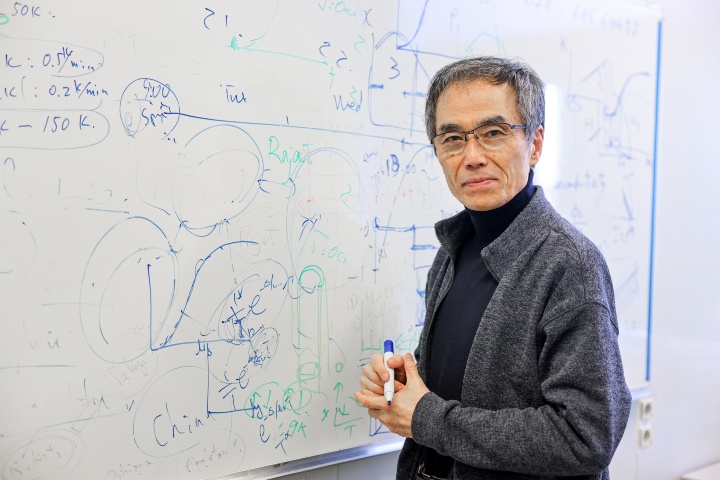 Professor Kazushi Kanoda steht vor einer beschrifteten weißen Tafel.