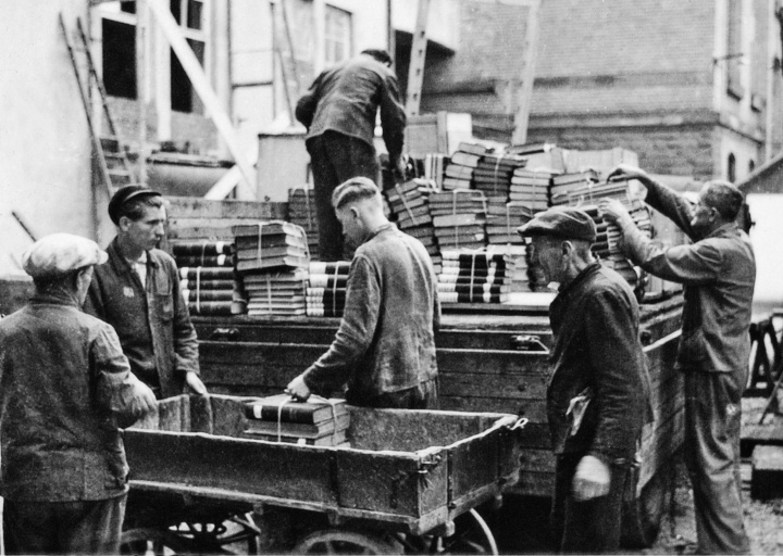 Zwangsarbeiter aus der Sowjetunion verladen um 1944 die Bibliothek der Materialprüfungsanstalt. Der zweite Mann von links trägt auf der Jacke den Schriftzug „OST“, der ihn als „Ostarbeiter“ kenntlich macht.