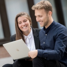 Katharina Hochmuth und Tim Hautkappe sehen zusammen auf einen Laptop.