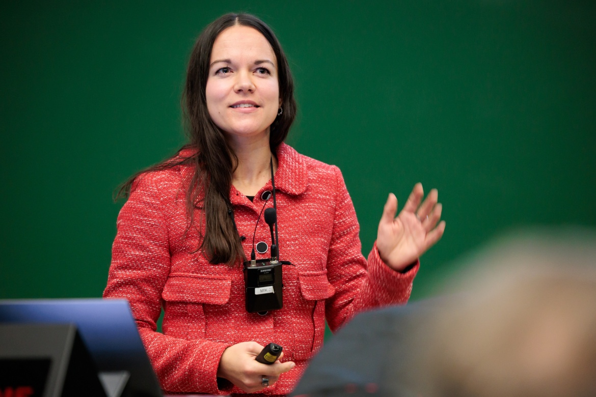 Eine Frau in einer roten Jacke, die eine Präsentation hält. Das Bild zeigt Professor Amrei Bahr, Institut für Philosophie (PHILO).