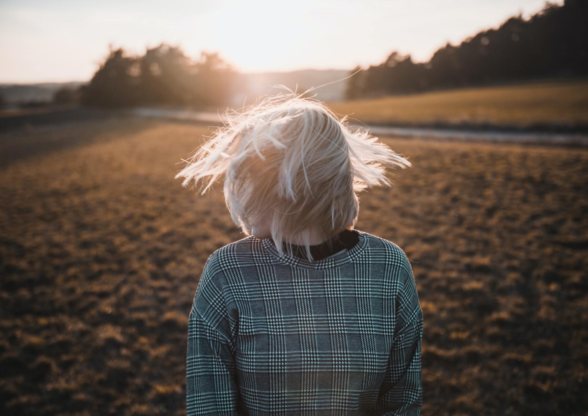 Frau schüttelt ihren Kopf und lässt die Haare fliegen.