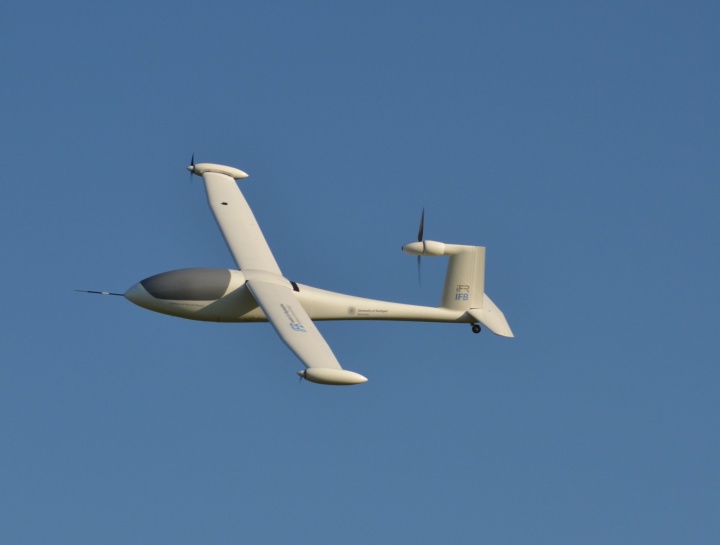 Das Flugzeugmodell mit dem Namen e-Genius Mod fliegt am blauen Himmel.