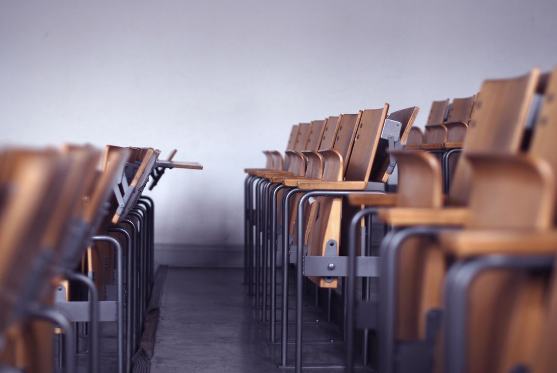 Symbolbild. Das Bild zeigt die leere Bankreihe eines Hörsaals. Die Studierenden sind zuhause, da das Studium digital stattfindet.