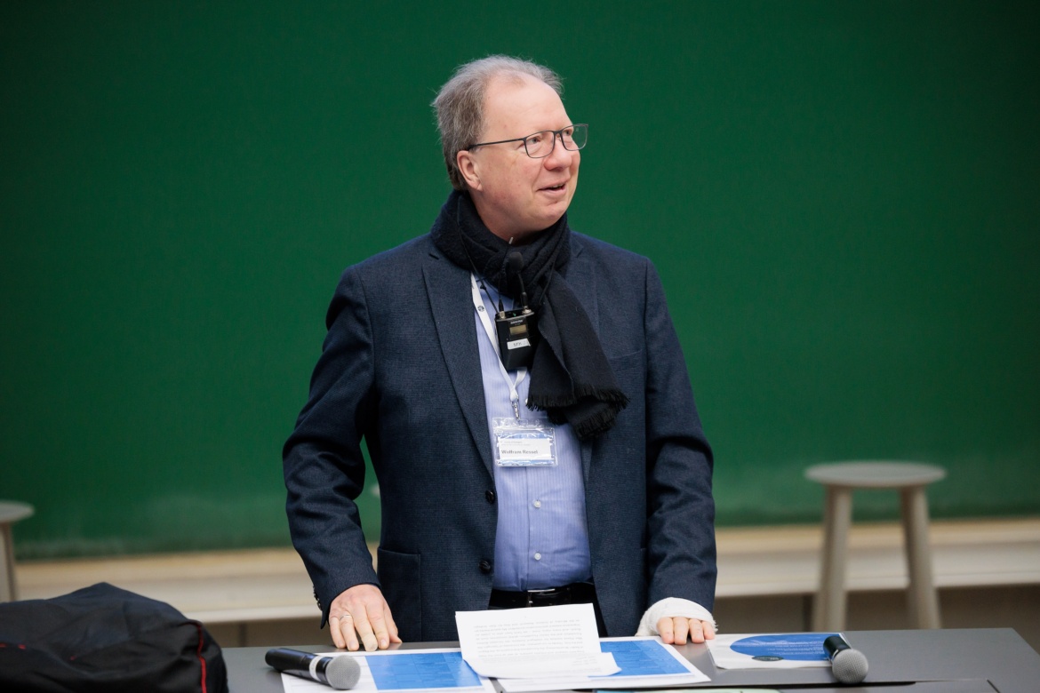 Ein Mann in einem Anzug steht vor einer Wandtafel. Das Bild zeigt Professor Wolfram Ressel, Rektor der Universität Stuttgart
