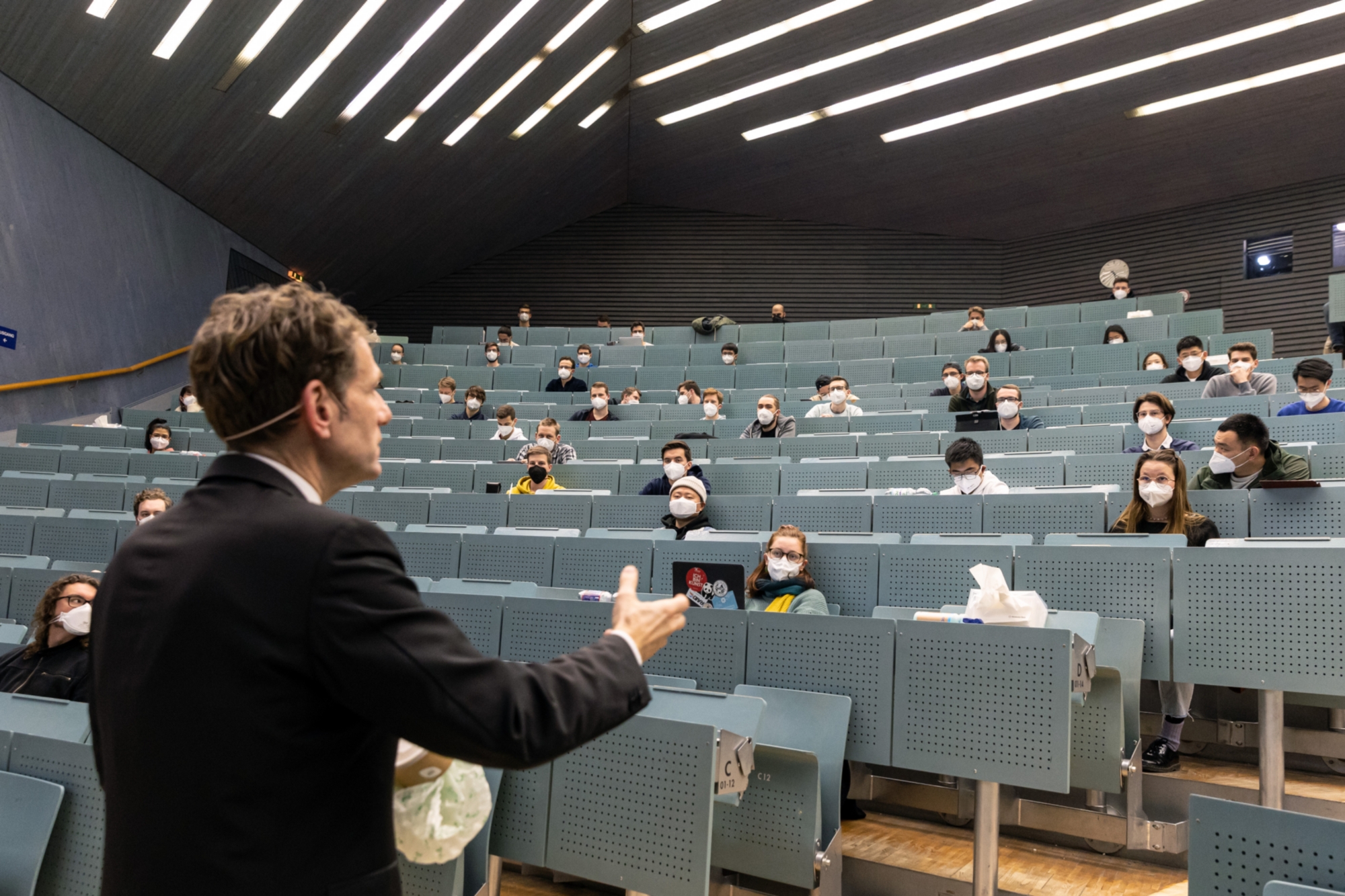 Prof. Bonten is giving a lecture. The students wear FFP2 masks and sit at a distance.