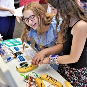 Fröhliche Kindern tüfteln mit Bananen